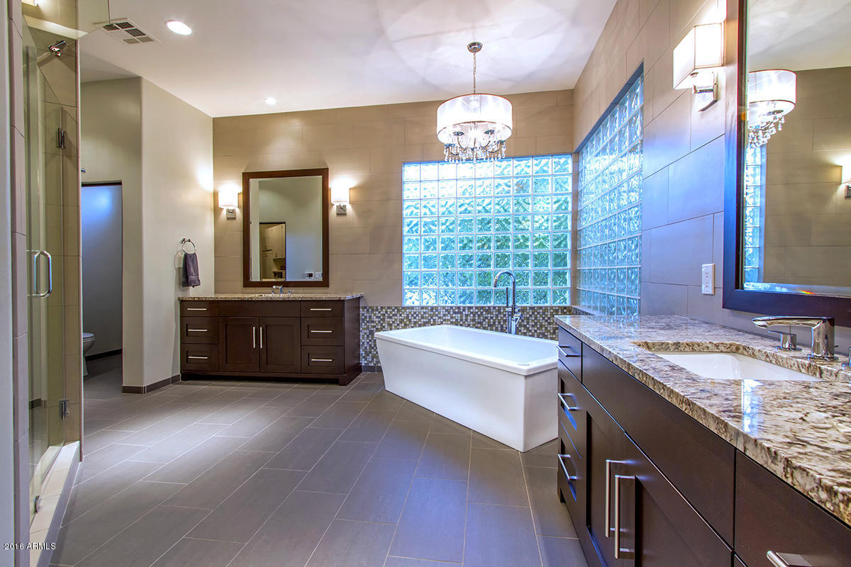4805 East Pebble Ridge Road Paradise Valley, AZ 85253 - Photo 13 of 37 a spacious bathroom with a tub double vanity sink and a mirror