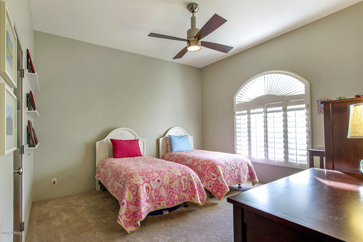 4805 East Pebble Ridge Road Paradise Valley, AZ 85253 - Photo 26 of 37 a bedroom with two beds and a chandelier