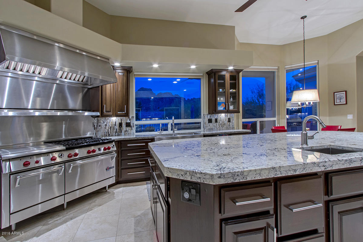 4805 East Pebble Ridge Road Paradise Valley, AZ 85253 - Photo 8 of 37 a kitchen with stainless steel appliances granite countertop a stove and a sink