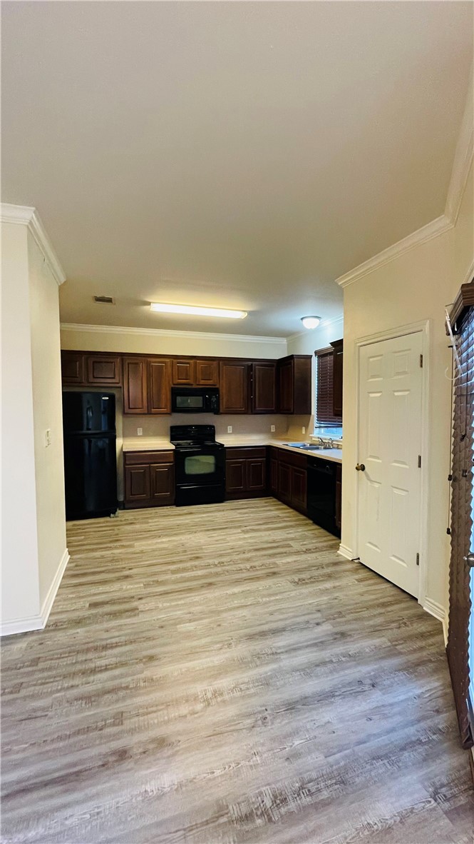 1425 West Villa Maria Road, Unit 602 Bryan, TX 77801 - Photo 40 of 41 a view of kitchen with kitchen island refrigerator sink and wooden floor
