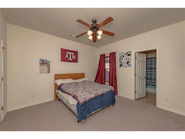 a living room with a bed and a ceiling fan
