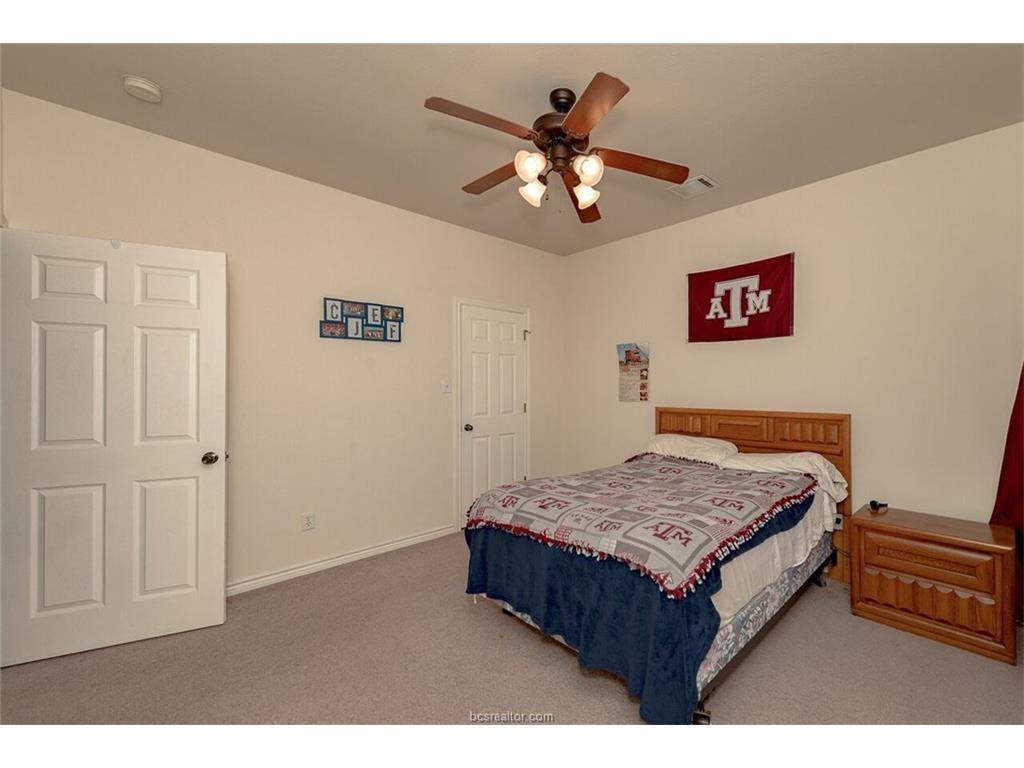 1425 West Villa Maria Road, Unit 602 Bryan, TX 77801 - Photo 8 of 12 a bedroom with a bed and a chandelier