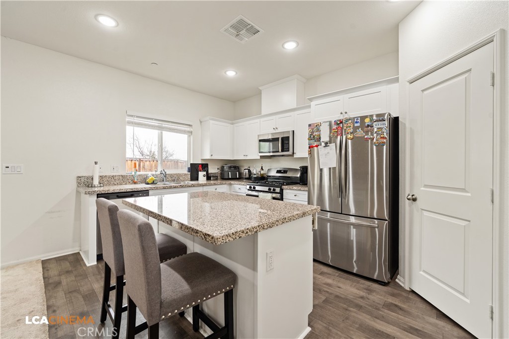 11112 Pasto Way Bakersfield, CA 93306 - Photo 11 of 35 a kitchen with kitchen island white cabinets and stainless steel appliances
