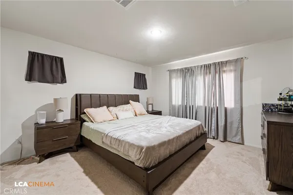 a bedroom with a bed and dresser with mirror
