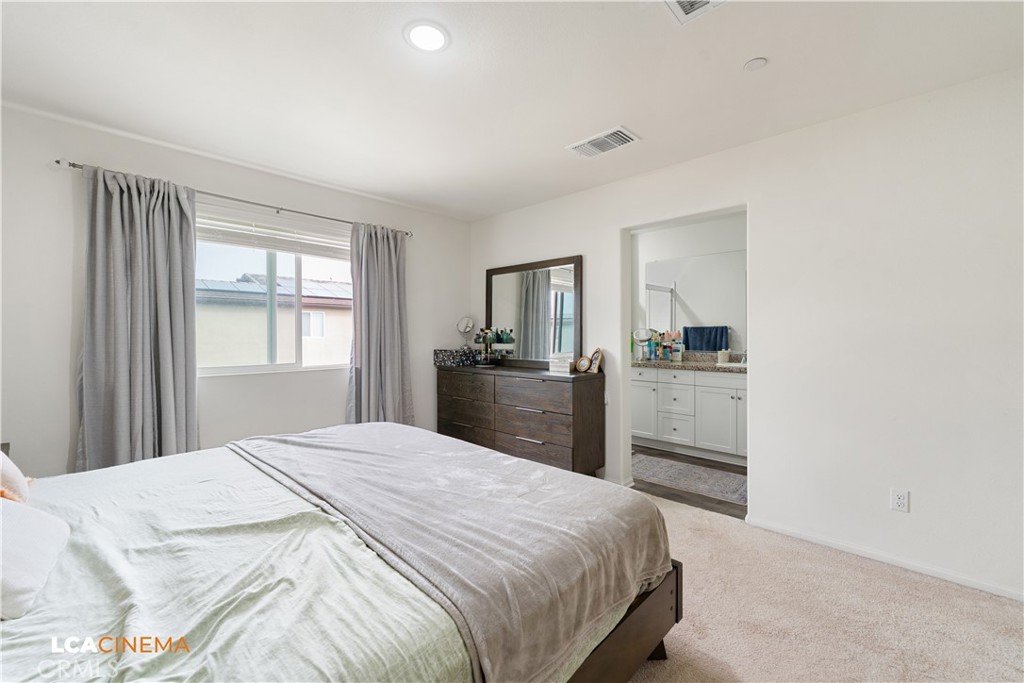 11112 Pasto Way Bakersfield, CA 93306 - Photo 14 of 35 a bedroom with a bed and dresser with mirror