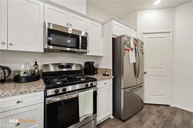 a kitchen with stainless steel appliances granite countertop a refrigerator stove and microwave