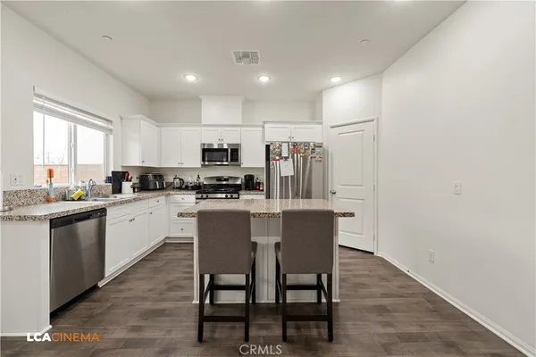 a kitchen with kitchen island white cabinets and stainless steel appliances