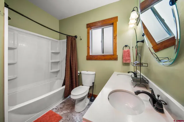 a bathroom with a sink a toilet and a mirror