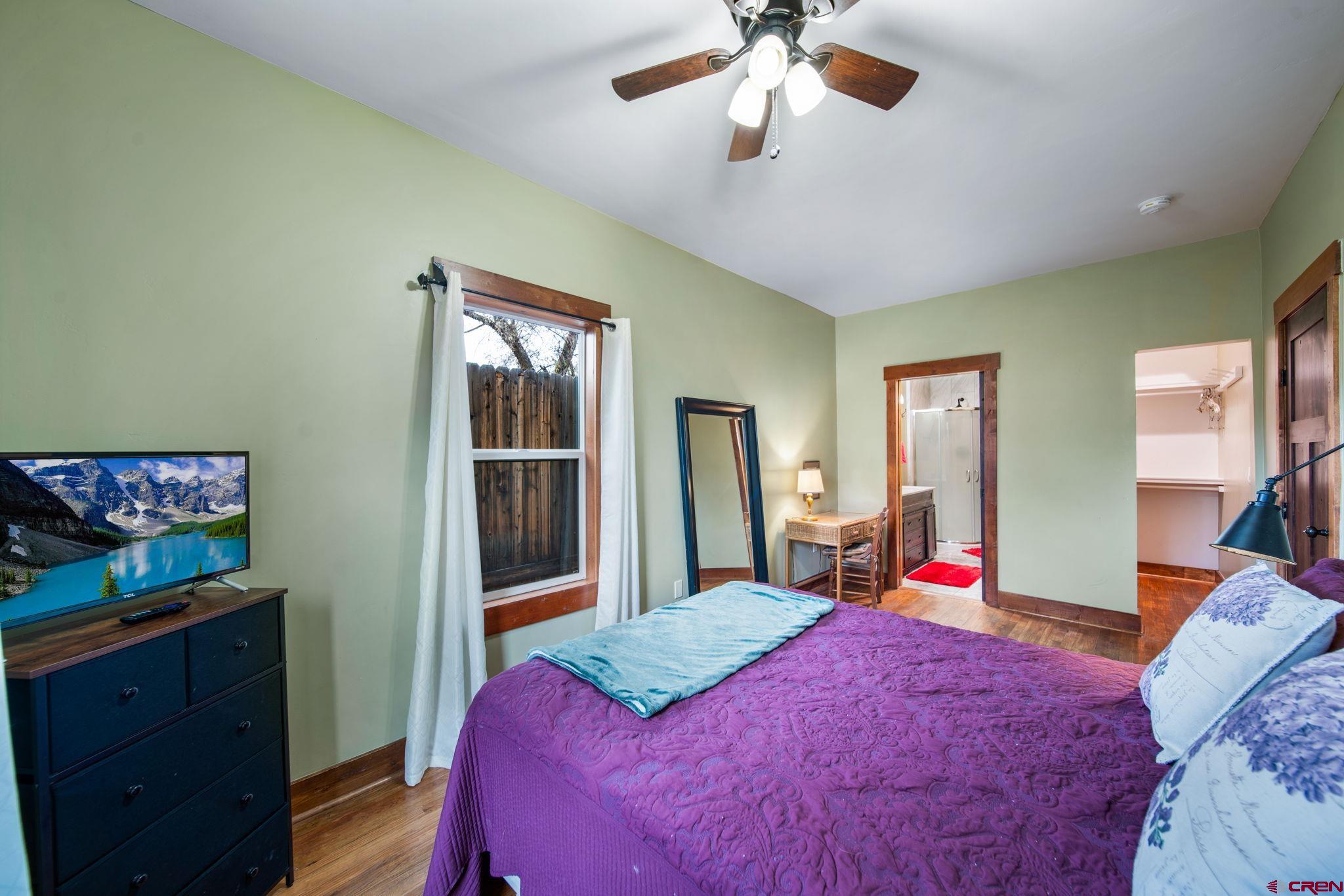 115 South Linden Street Cortez, CO 81321 - Photo 14 of 30 a bedroom with a bed and a chandelier