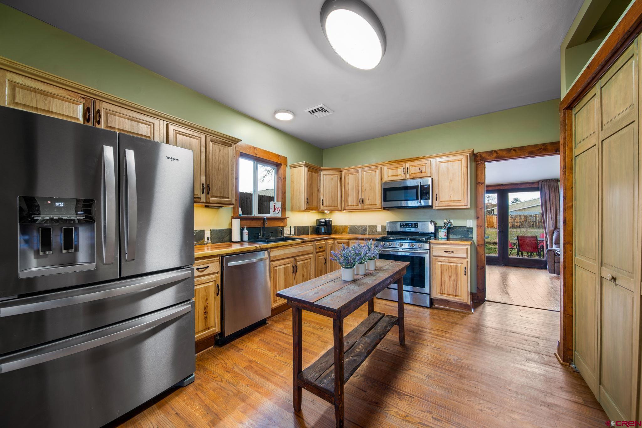 115 South Linden Street Cortez, CO 81321 - Photo 7 of 30 a kitchen with stainless steel appliances granite countertop a refrigerator stove top oven and sink