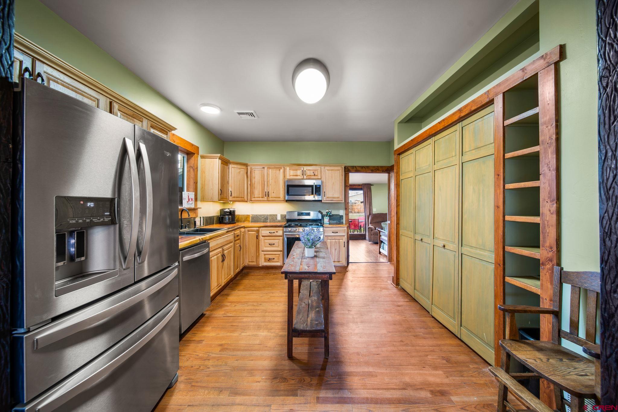 115 South Linden Street Cortez, CO 81321 - Photo 8 of 30 a kitchen with stainless steel appliances granite countertop a refrigerator and wooden cabinets