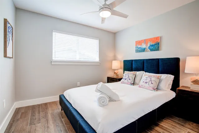 a bedroom with a bed and a painting on the wall