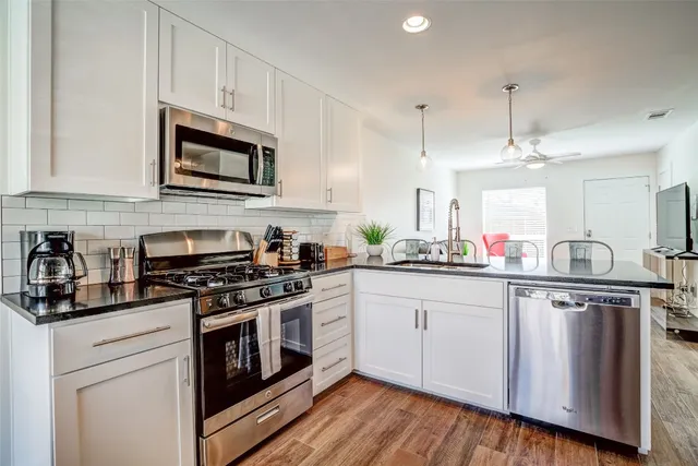 a kitchen with white cabinets stainless steel appliances and sink