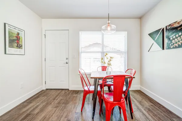 a dining room with furniture a chandelier and wooden floor