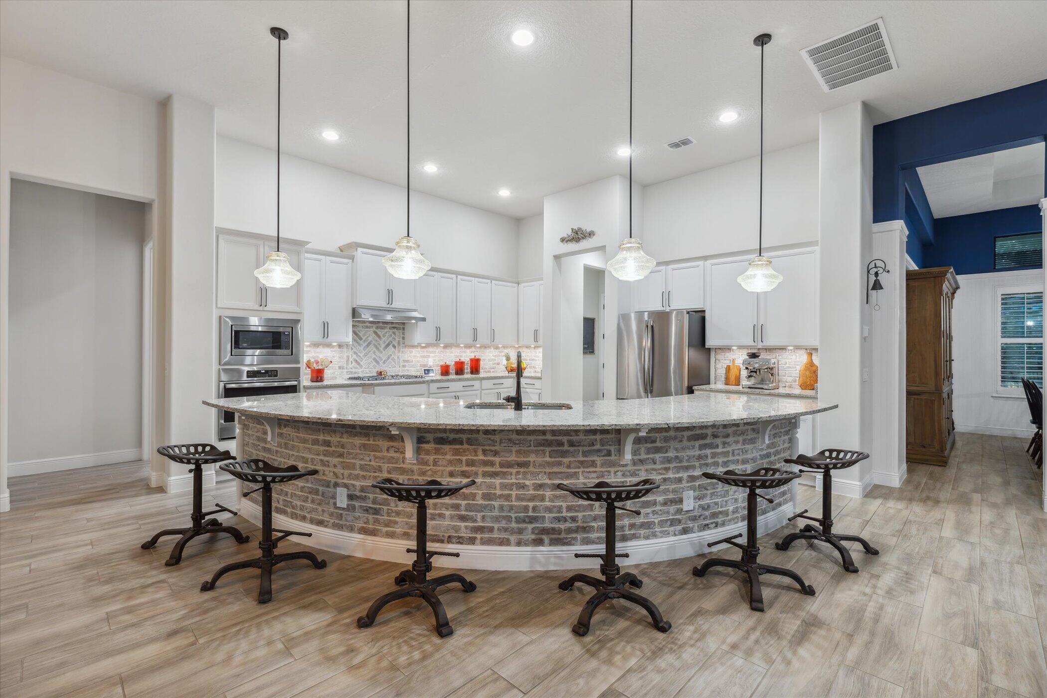 5420 Calder Drive Melbourne, FL 32940 - Photo 25 of 73 a kitchen with kitchen island stainless steel appliances a dining table chairs sink and wooden floor
