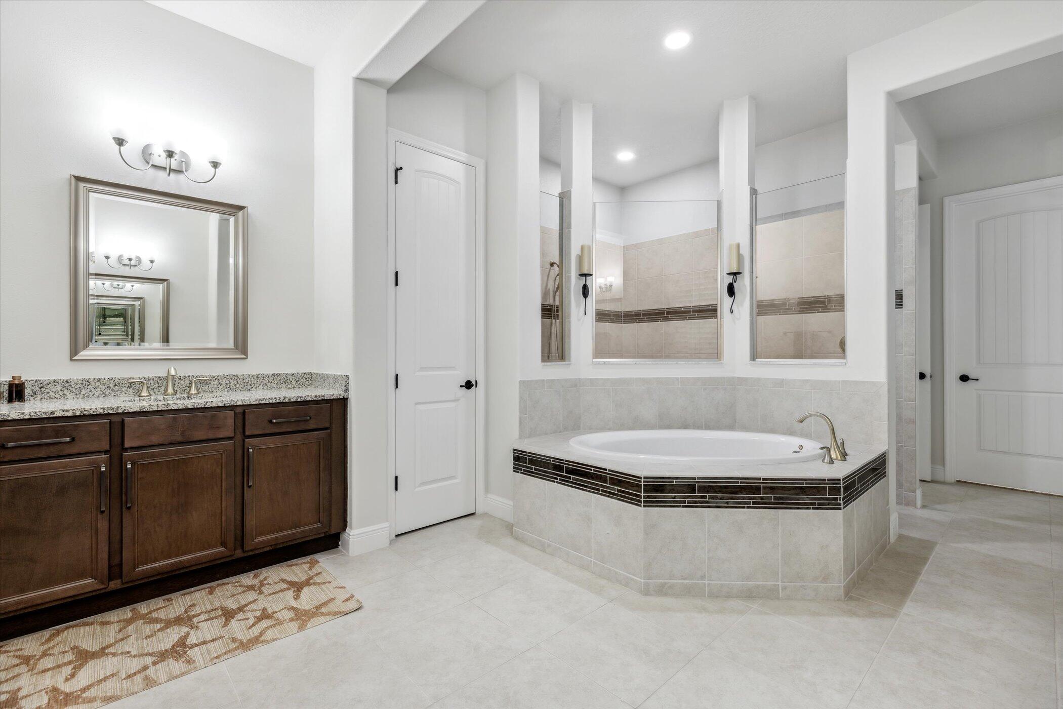 5420 Calder Drive Melbourne, FL 32940 - Photo 44 of 73 a bathroom with a granite countertop tub a double vanity sink a mirror and a shower