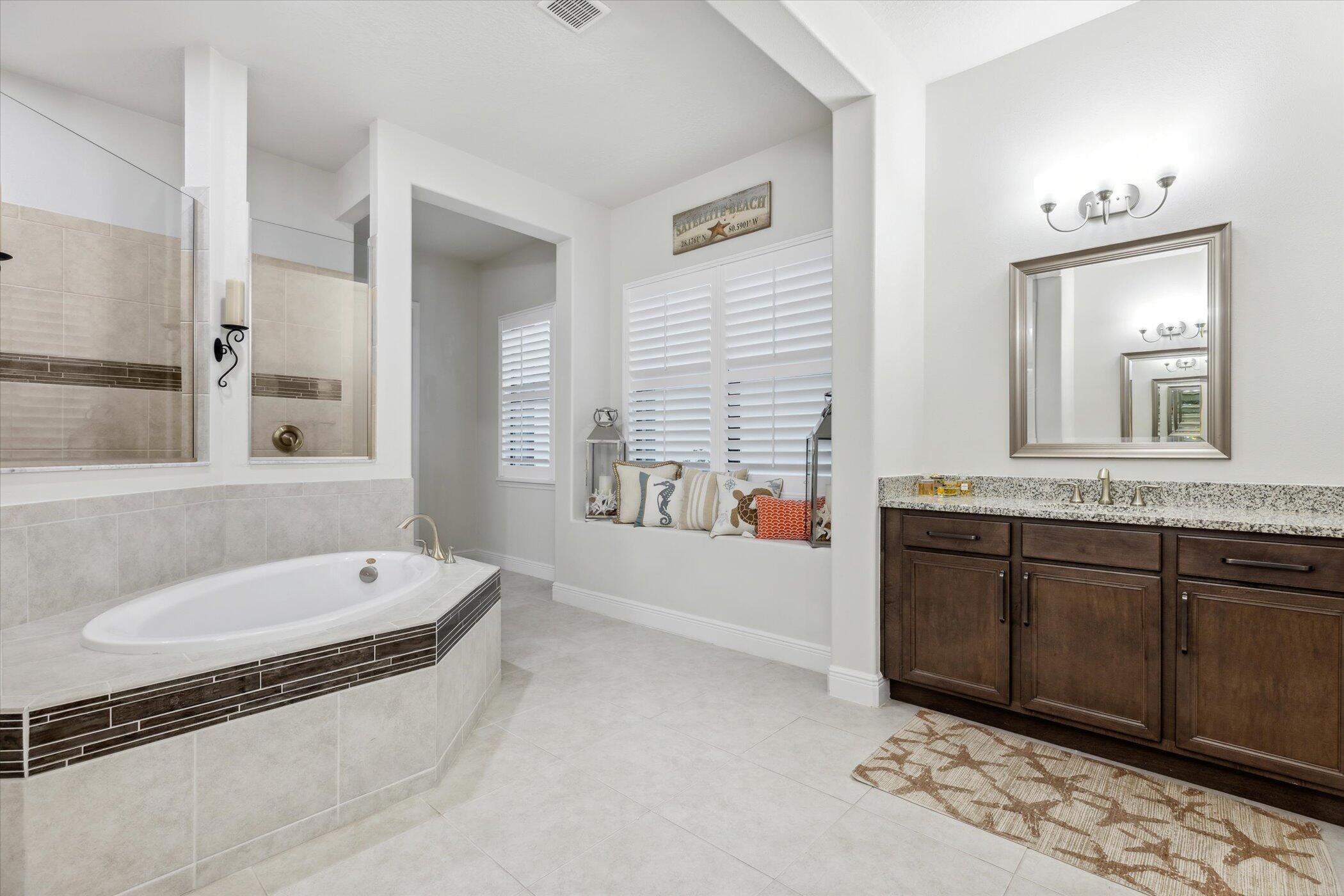 5420 Calder Drive Melbourne, FL 32940 - Photo 45 of 73 a spacious bathroom with a granite countertop tub sink and mirror
