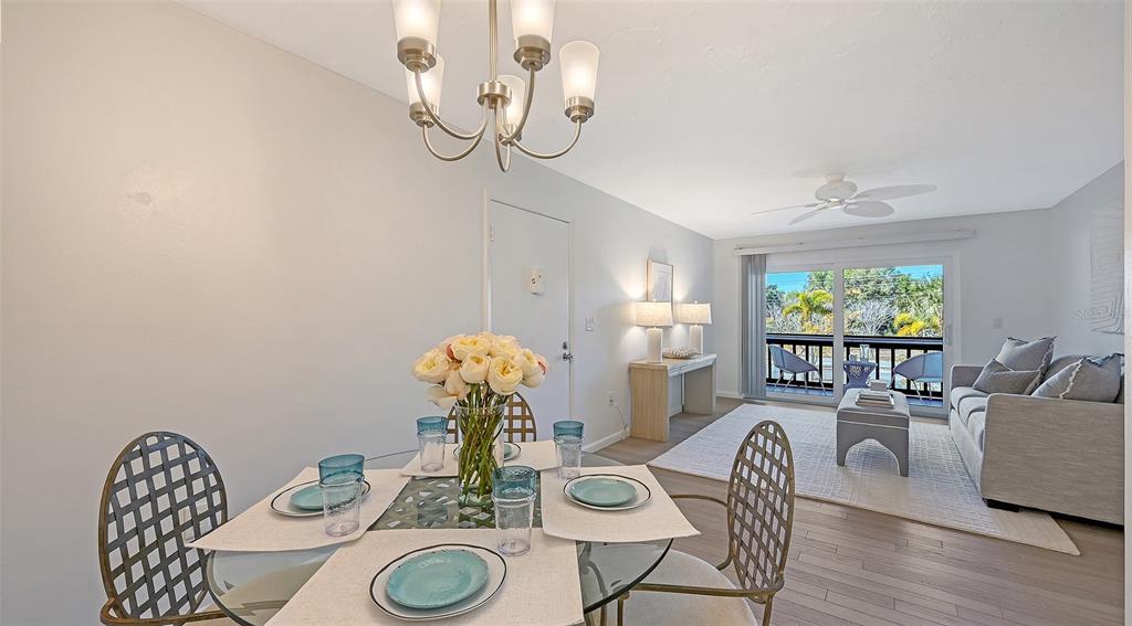 3201 South Beneva Road, Unit 204 Sarasota, FL 34232 - Photo 11 of 34 a view of a dining room with furniture wooden floor and chandelier