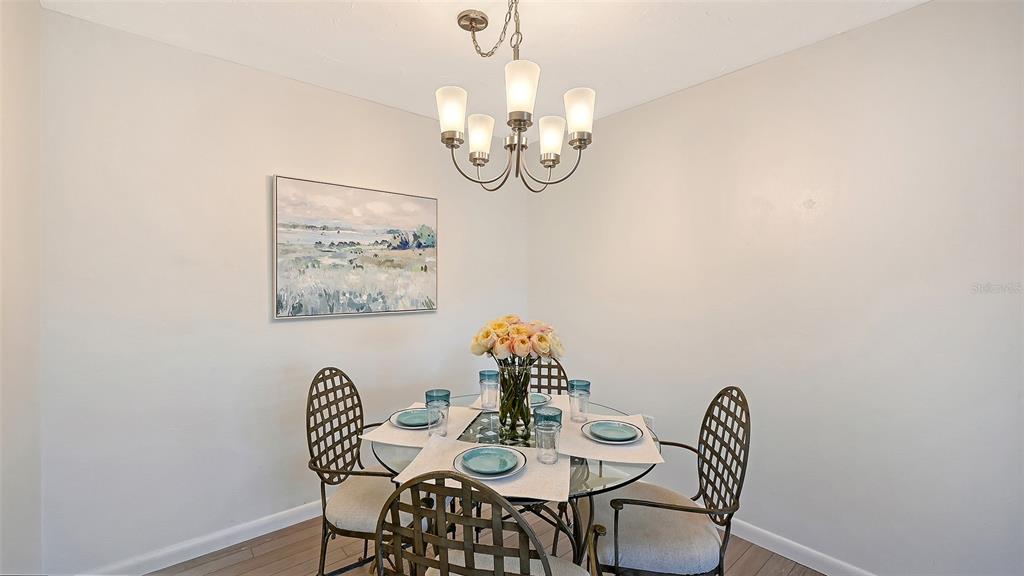 3201 South Beneva Road, Unit 204 Sarasota, FL 34232 - Photo 12 of 34 a view of a dining room with furniture and wooden floor