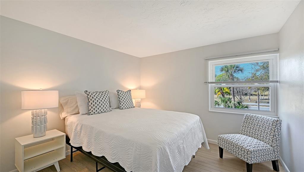 3201 South Beneva Road, Unit 204 Sarasota, FL 34232 - Photo 19 of 34 a bedroom with a bed and wooden floor