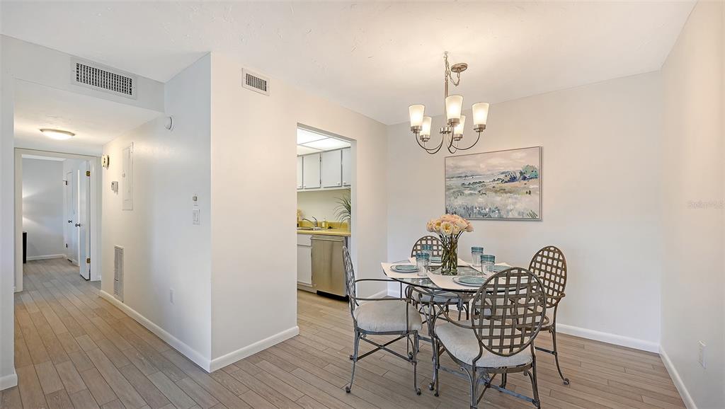 3201 South Beneva Road, Unit 204 Sarasota, FL 34232 - Photo 9 of 34 a view of a dining room with furniture and wooden floor