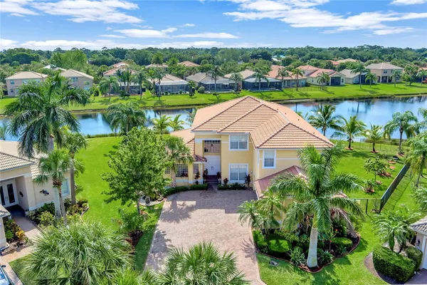an aerial view of a house with a garden and lake view