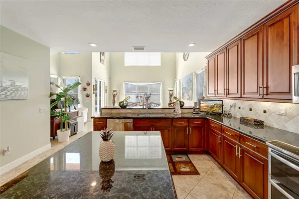 a large kitchen with stainless steel appliances granite countertop a sink and a counter