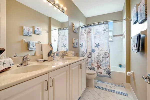 a bathroom with a double vanity sink toilet and shower