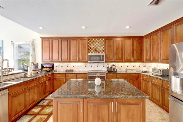 a large kitchen with lots of counter space sink and cabinets