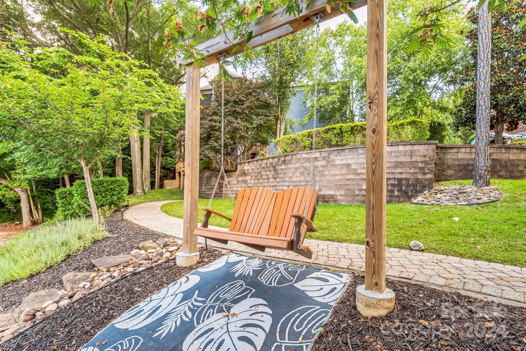 936 Rocky Point Lane Tega Cay, SC 29708 - Photo 19 of 48 a view of a backyard with couches plants and large trees