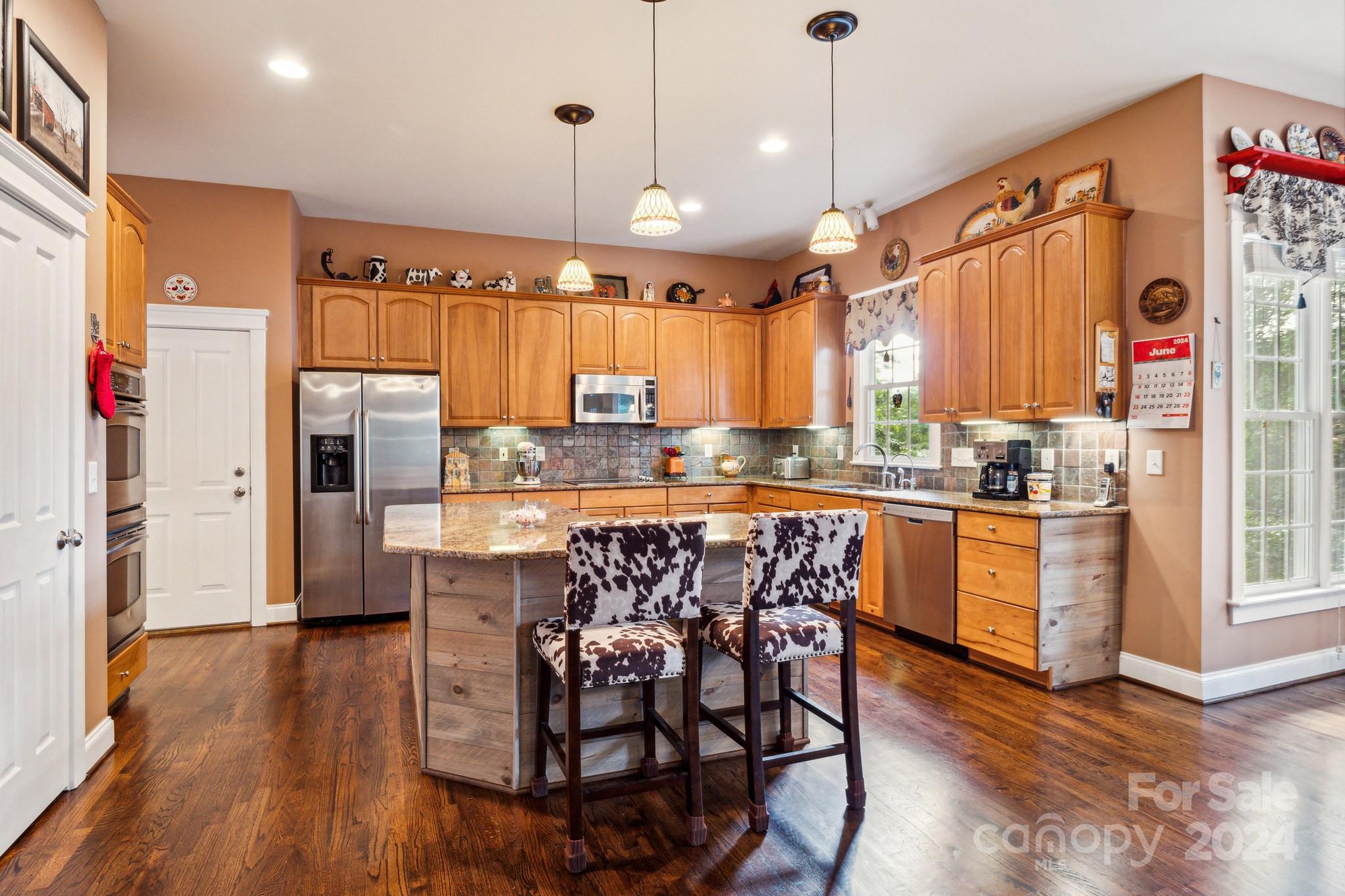 936 Rocky Point Lane Tega Cay, SC 29708 - Photo 44 of 48 a kitchen with stainless steel appliances granite countertop a refrigerator a oven a sink and a dining table with wooden floor
