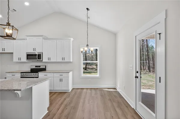 a kitchen with stainless steel appliances granite countertop a sink stove and cabinets