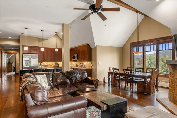 a living room with furniture a ceiling fan and a large window