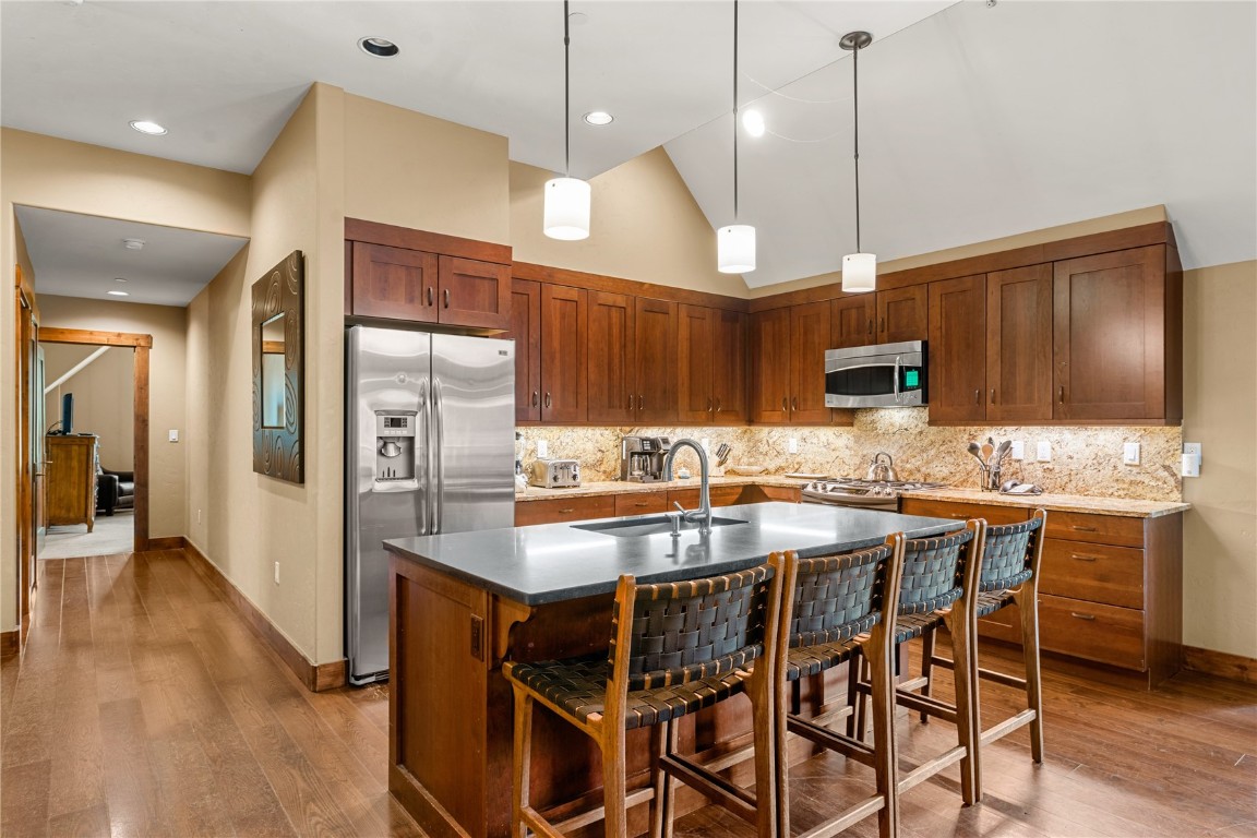 600 Columbine Road, Unit 5310 Breckenridge, CO 80424 - Photo 11 of 38 a kitchen with stainless steel appliances kitchen island a table and chairs in it