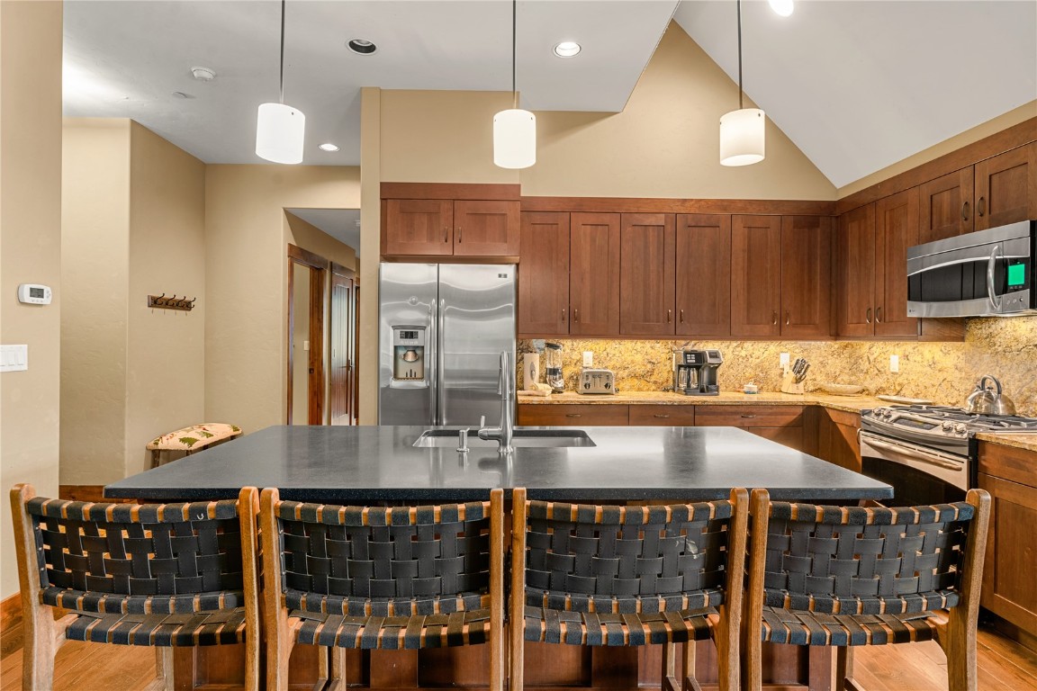 600 Columbine Road, Unit 5310 Breckenridge, CO 80424 - Photo 12 of 38 a kitchen with a dining table chairs cabinets and stainless steel appliances