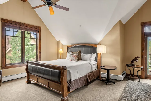 a bedroom with a bed a chandelier and a dresser next to a window