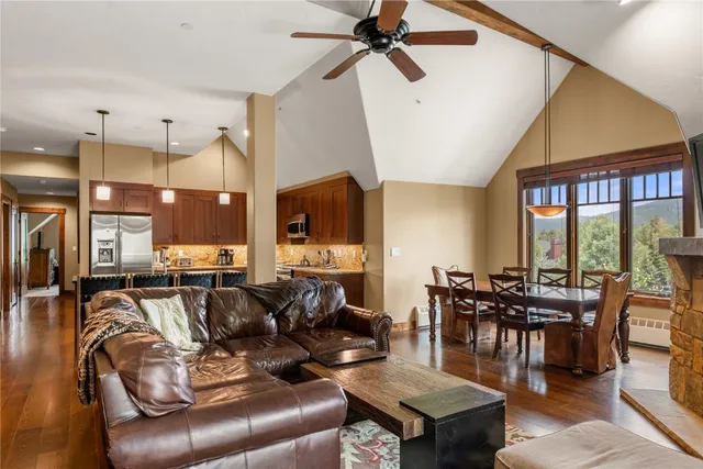 a living room with furniture a ceiling fan and a large window