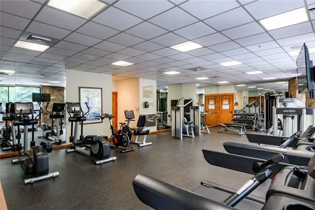 a room with gym equipment and a view of gym