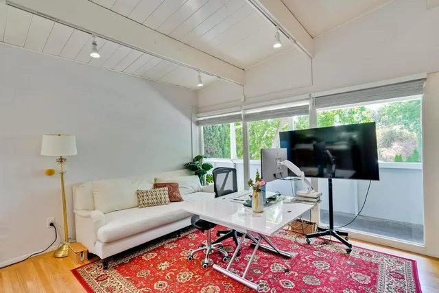 a view of a workspace with furniture and a window