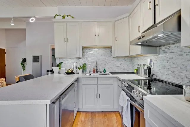 a kitchen with a sink a stove and cabinets