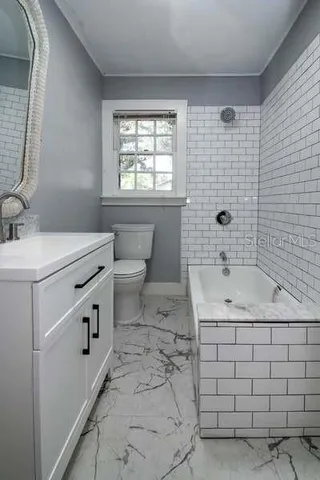 a bathroom with a sink a toilet and window