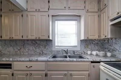 a kitchen with stainless steel appliances granite countertop a sink a stove and a granite counter tops