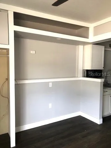 a view of a big room with wooden floor and windows
