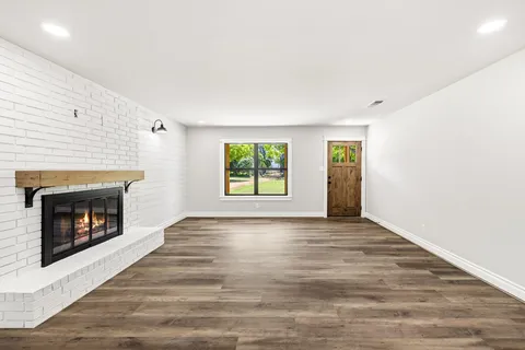 a view of an empty room with window and fire place