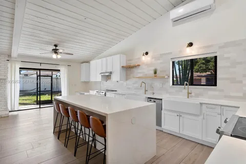 a kitchen with a sink a center island cabinets and a window