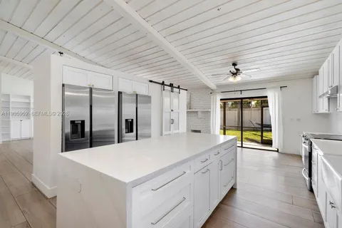 a large white kitchen with a large window