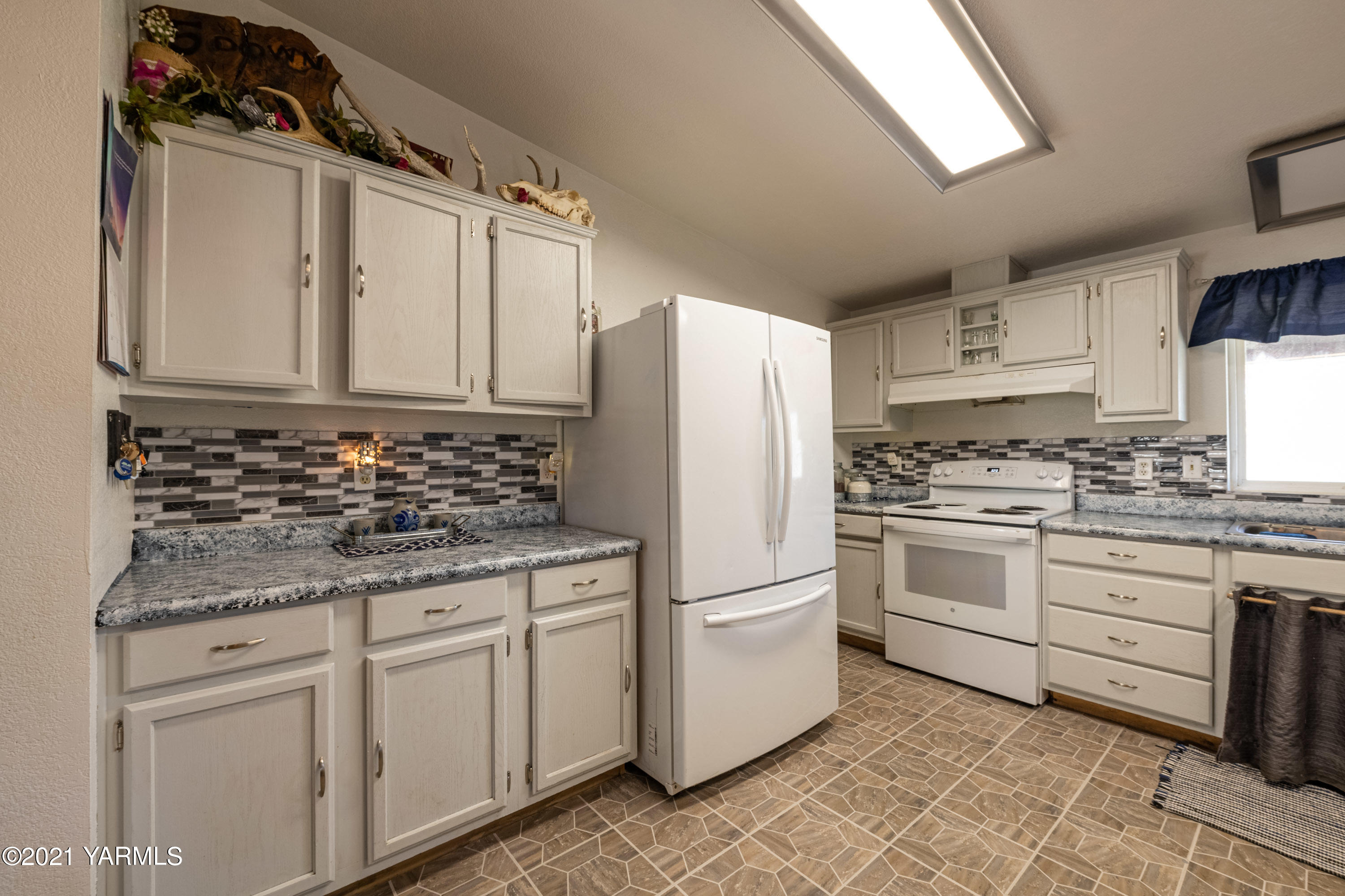 1222 Almo Road Yakima, WA 98901 - Photo 9 of 23 a kitchen with granite countertop white cabinets and white appliances