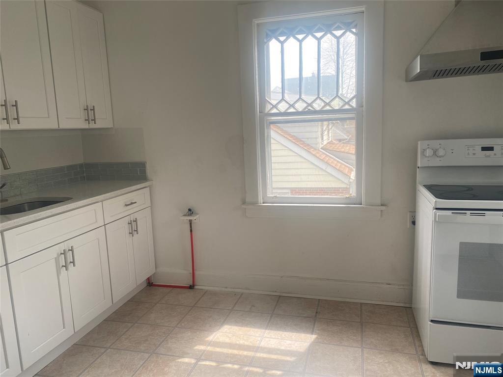 30 North Demarest Avenue Bergenfield, NJ 07621 - Photo 4 of 12 a kitchen with white cabinets and a window