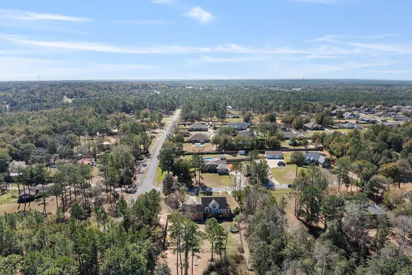 an aerial view of residential houses with outdoor space and trees