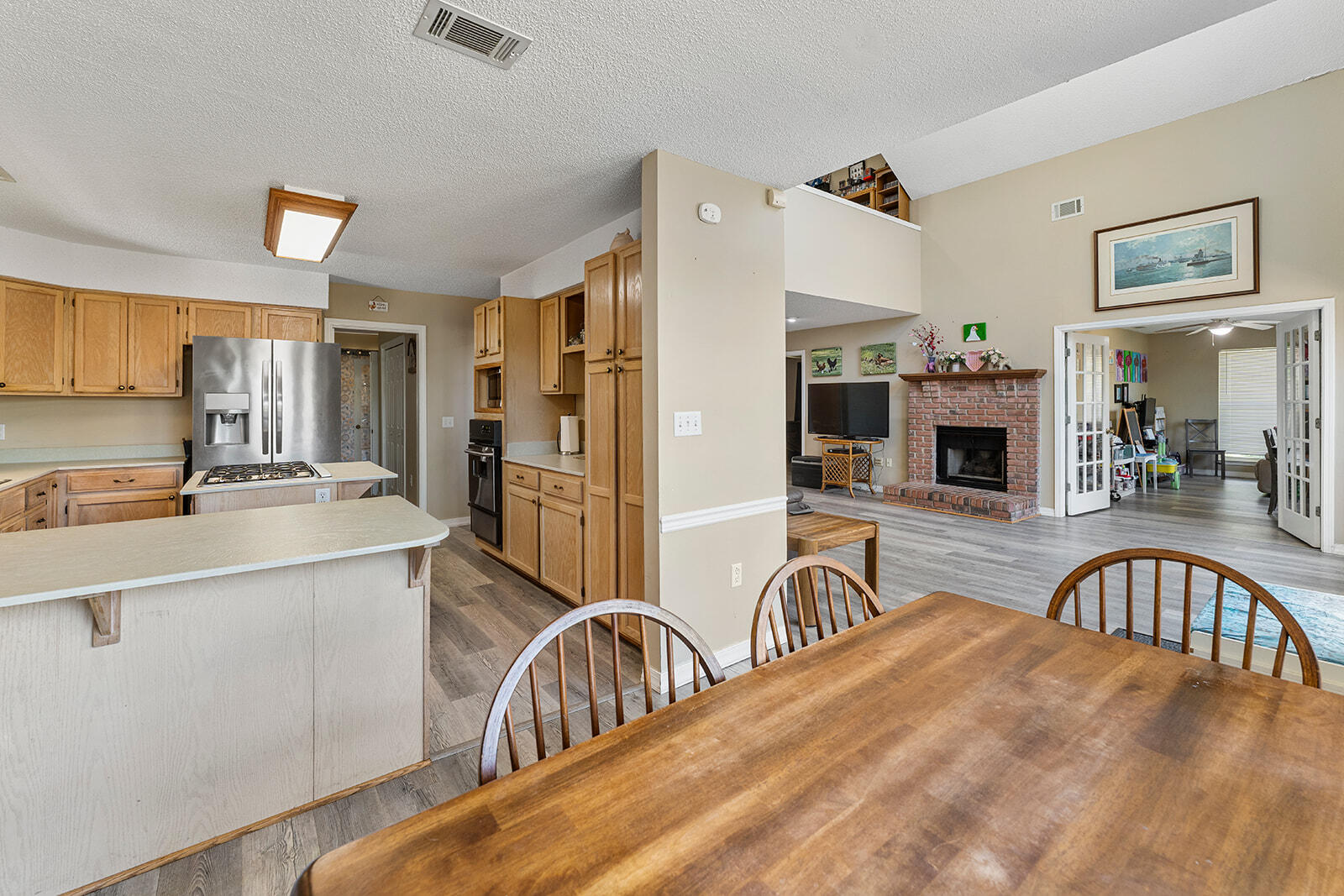 132 Wedgewood Lane Crestview, FL 32536 - Photo 10 of 67 a kitchen with stainless steel appliances granite countertop a sink a stove a refrigerator cabinets a dining table and chairs with wooden floor